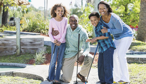 happy family posing on miniature golf course