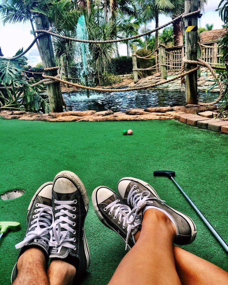 mini golf players on course with Chuck Taylor shoes