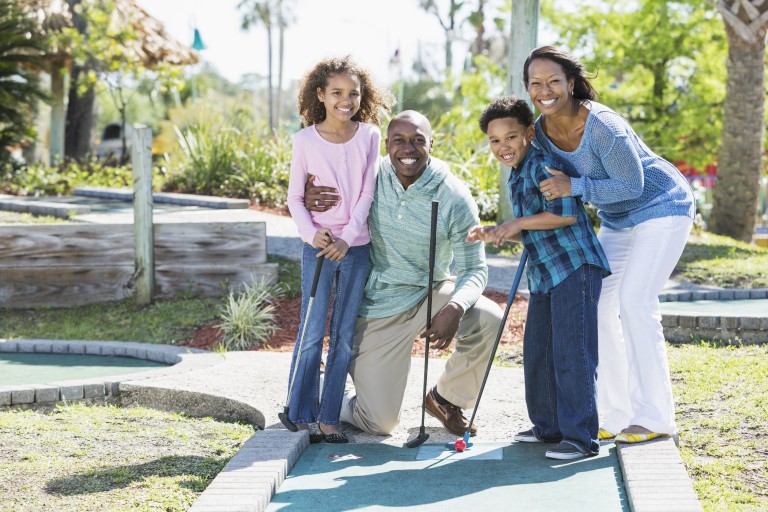Happy Family posed on mini golf course hole